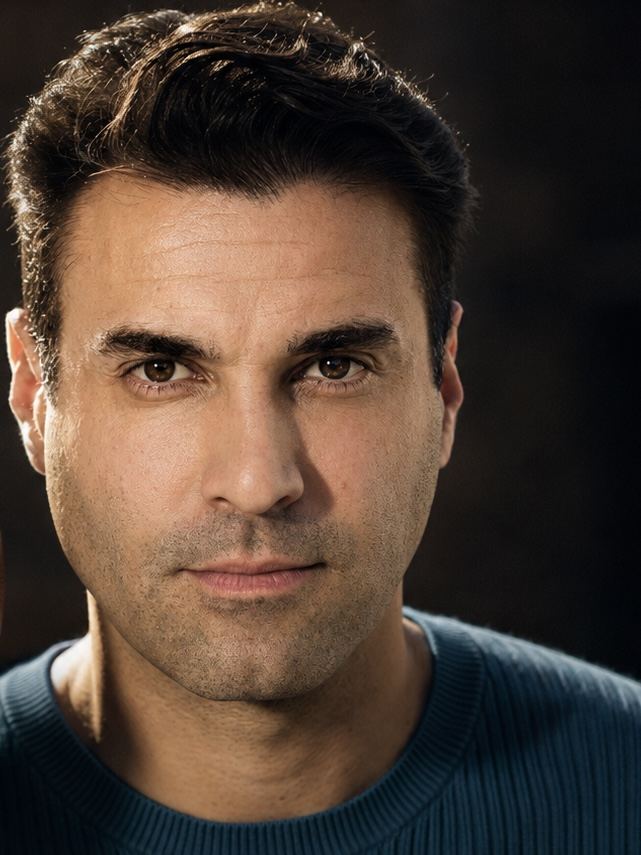 Close-up headshot of A.J. Castro in a blue sweater